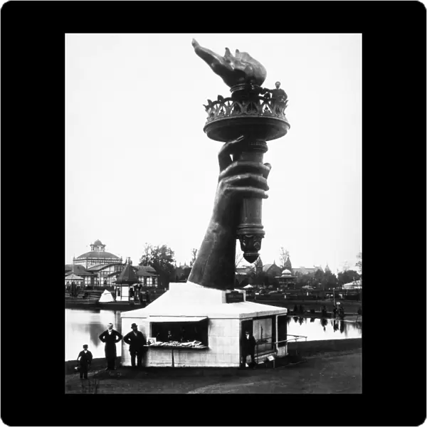 CENTENNIAL FAIR, 1876. The hand of the Statue of Liberty exhibited at the Centennial Exposition in Philadelphia, Pennsylvania, 1776. The sculptor, FrÔÇÜ dÔÇÜ ric Bartholdi, poses alongside the flame