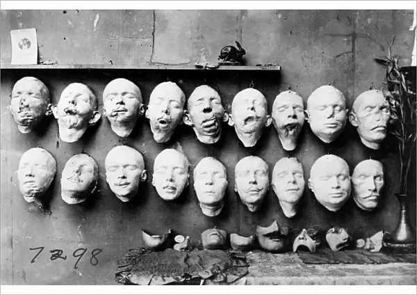 WORLD WAR I: MASKS, 1918. Masks showing the work done by Anna Coleman Ladd of the American Red Cross. The top row are casts taken from soldiers mutilated faces, the bottom row shows masks of their faces before their injuries, made from pre-war photographs. On the table are masks made to fit over the disfigured part of the face. Photograph, 1918