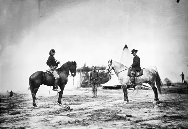 GEORGE CUSTER (1839-1876). American army officer. Custer, left, as a Captain in the Union Army, with General Alfred Pleasonton in April 1863