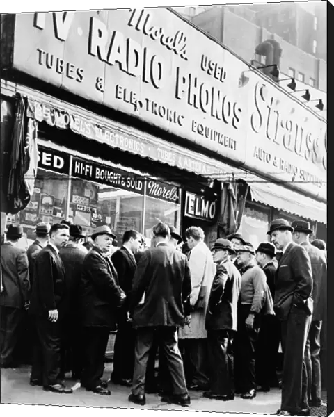 A crowd gathered around a radio shop at Greenwich and Dey Streets in New York City, listening for news on President John F. Kennedy after he was shot, 22 November 1963. Photograph by Orlando Fernandez
