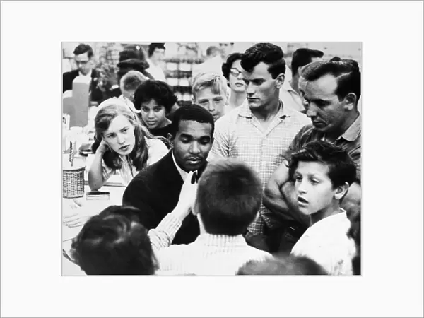 Dion Diamond, a civil rights activist and student at Howard University in Washington, D. C. is surrounded by white youths during a sit-in demonstration at a drug store in Arlington, Virginia, 9 June 1960