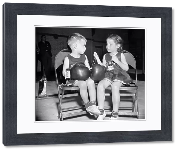 JUNIOR BOXER, 1939. Dorothy Wood, age 5, laces the boxing gloves of her companion, Chuck Andrews, age 3, at the U. S. Naval Academys 20th Annual Junior Boxing Championships, in Annapolis, Maryland, 1939