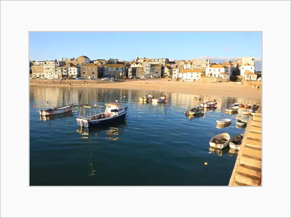 St Ives. Colourful little open Fishing Boats lit by pale afternoon sun light