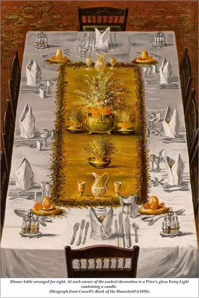 Dinner table arranged for eight. At each corner of the central decoration is a Prices s
