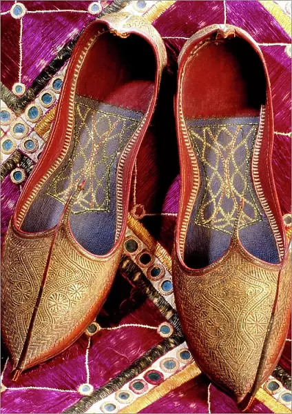 Still-life, antique shoes, Indian slippers in red leather with decorations in gold thread and curved tip upwards, about 1920