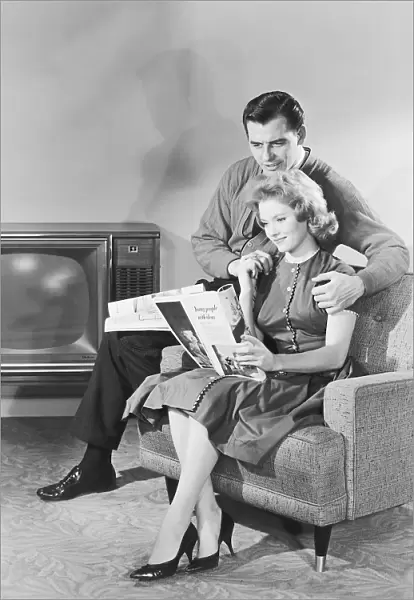 Couple looking at a magazine together