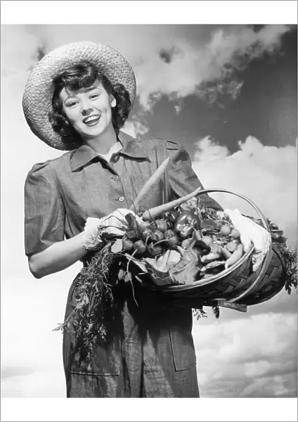 Historic portrait of woman holding a basket of fresh vegetables, black and white