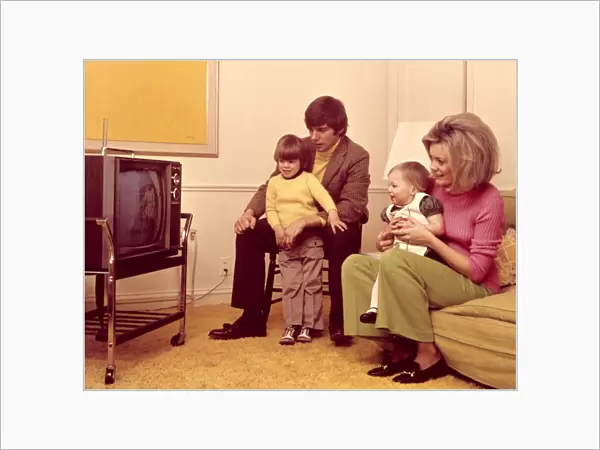Family watching TV in 1970s home