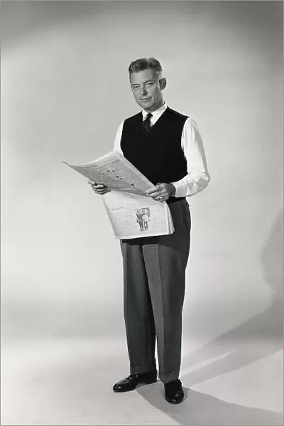 Indoor portrait of man reading newspaper