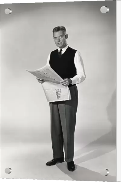 Indoor portrait of man reading newspaper