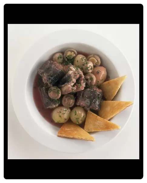 Matelote d Anguilles, eel stewed in red wine with mushrooms and onions, served with slices of toasted bread, a traditional dish from the Loire Valley, France, view from above