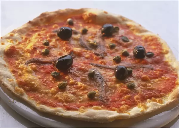 Round pizza with thin base and thin, crispy crust, topped with tomato sauce, whole olives, anchovies, capers and cheese