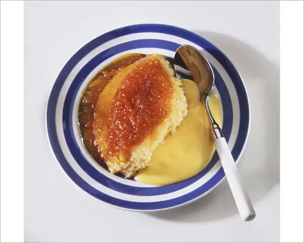 Syrup Pudding, traditional steamed dessert sweetened with golden syrup, served in bowl with custard
