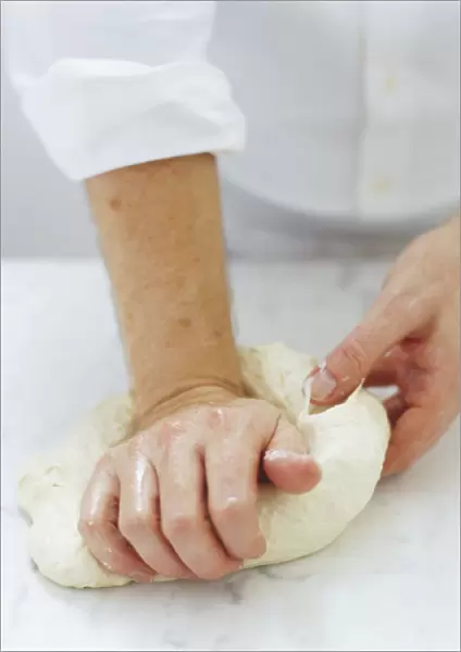 Using right hand to press down dough