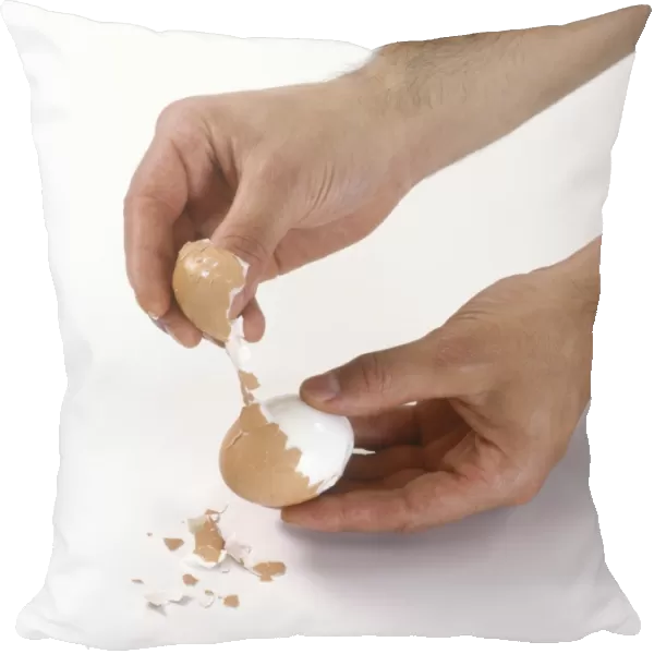 Hands taking shell off hard boiled egg