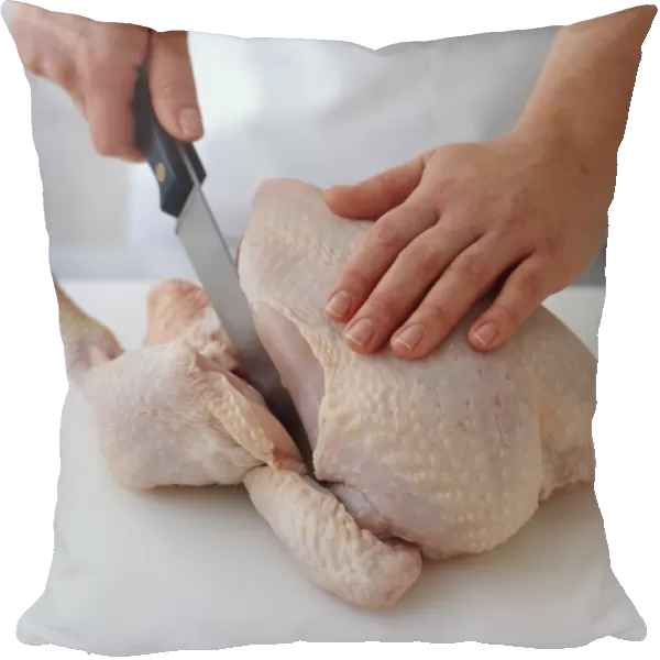 Person cutting raw chicken