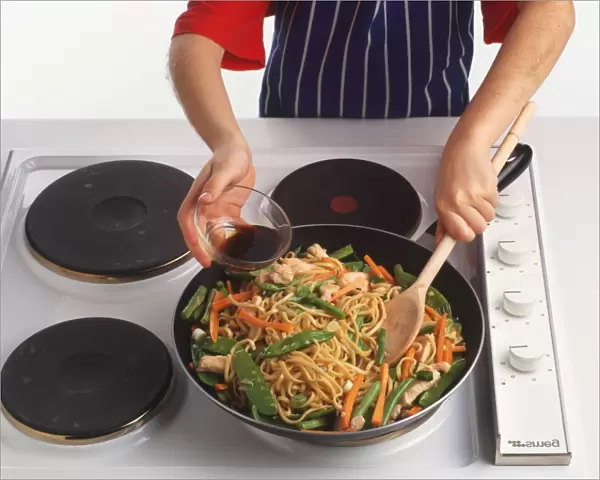 Noodles being mixed into chicken and vegetable mixture