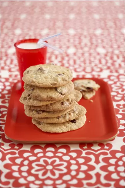 Glass of milk next to cookies white chocolate and cranberry