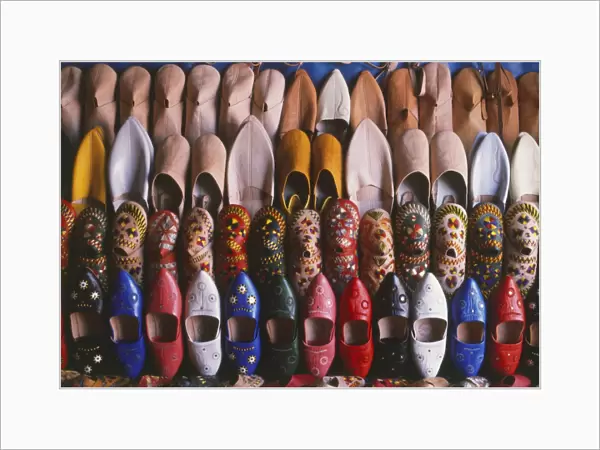 Morocco, rows of colourful leather slippers laid out for sale