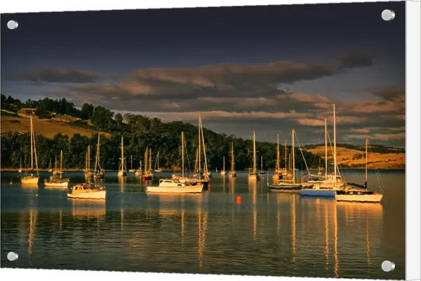 Afternoon light sweeps across the moored boats in the protected and picturesque bay at Kettering, southern Tasmania