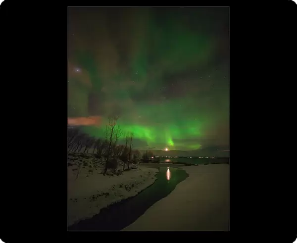 Aurora Borealis lights up the sky behind the city of Akureyri, Iceland