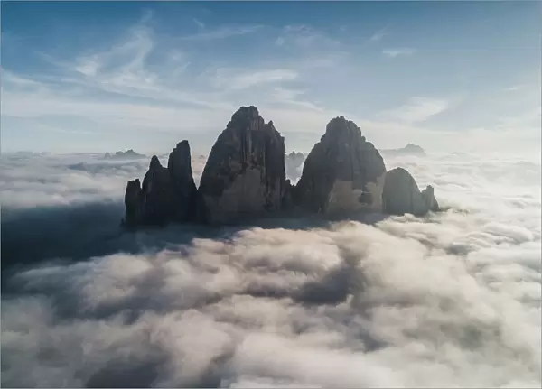 Majestic aerial shot above the clouds looking towards Tre Cime Di Lavaredo, Italy