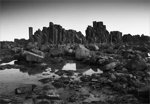 Monochrome, Dramatic coastal basalt columns rock formations at sunset at the disused
