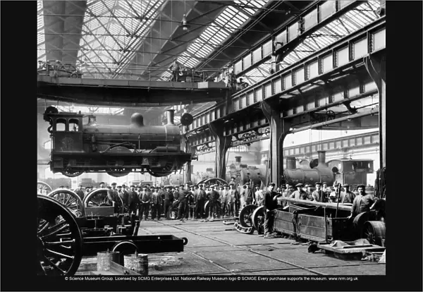 Crowds watching a suspended locomotive at the North Eastern Railways Gateshead Works