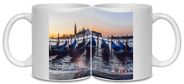 Sunrise view on gondola station near Piazza San Marco with Church of San Giorgio Maggiore on the backround during the rising tide