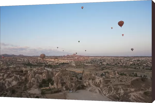 Hot air balloons flying over dramatic landscape