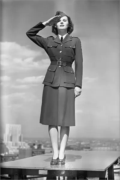 Female soldier standing on table and saluting