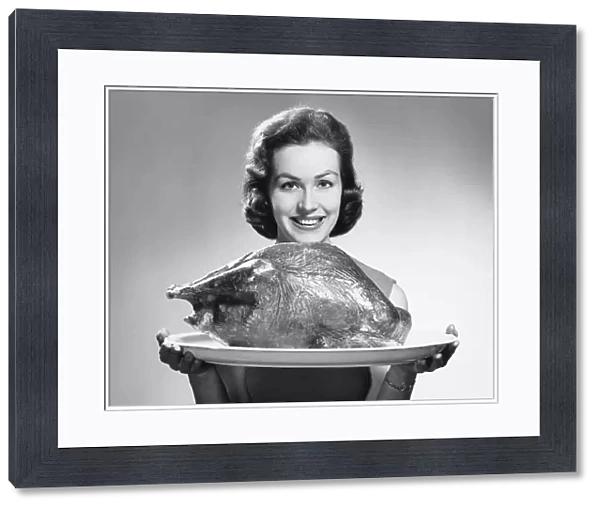 Woman holding platter with roast turkey