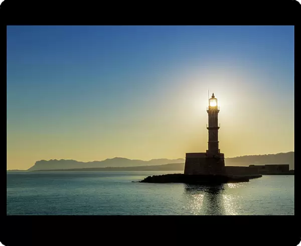 Chania lighthouse with the sun right behind, at sunrise, harbour, Chania, Crete, Greece