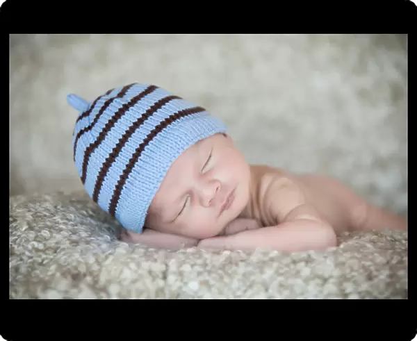 Newborn baby, 3 weeks, sleeping, wearing a hat