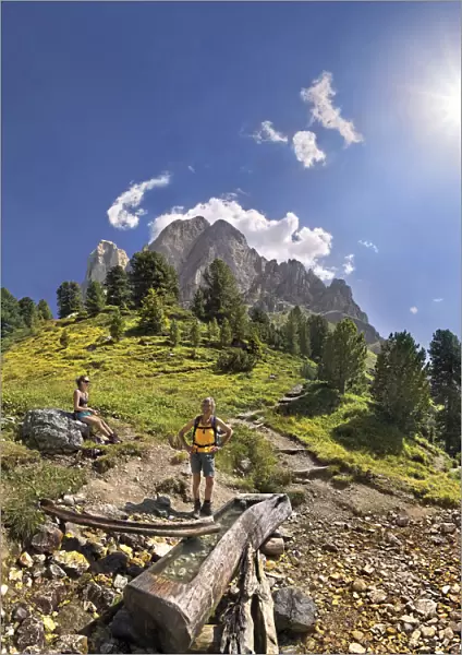 Small spring at Mt Peitlerkofel, Sasso delle Putia, with hiker at Wuerzjoch, Passo delle Erbe, Villnoess, Funes, Dolomites, South Tyrol, Italy, Europe