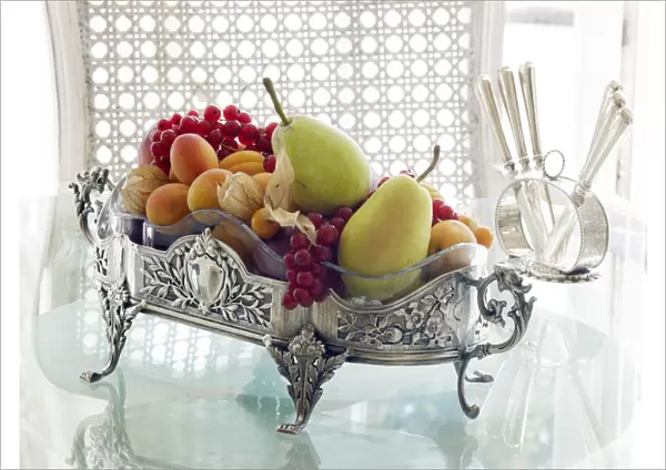 Antique silver fruit bowl with fruit in a sophisticated atmosphere on a breakfast table