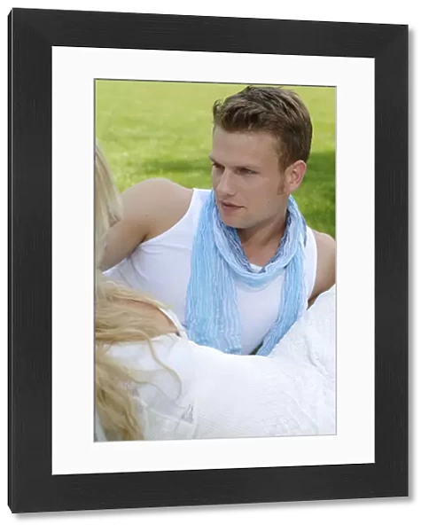 Young man in the arms of a woman on a lawn