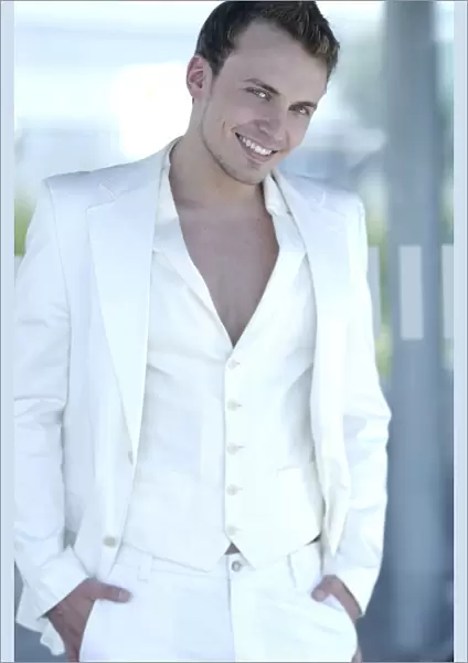 Young man wearing a white suit, smiling
