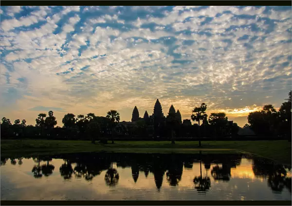 Angkor Wat temple at sunrise reflecting in water