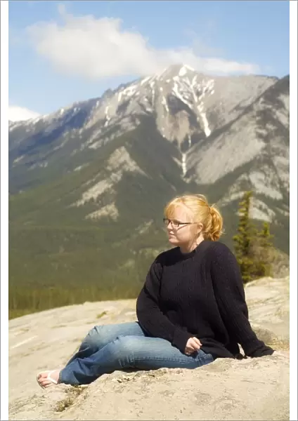 Young woman sitting in the mountains, Jasper, Canada