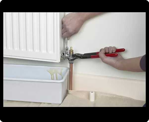 Unlock the bleed valve on a radiator, container underneath radiator