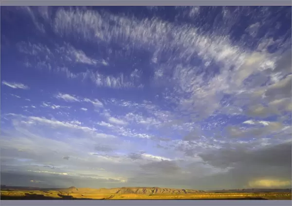 USA, Utah, Goosenecks State Park, clouds in sky over desert at sunset