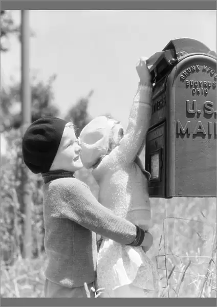 Boy lifting up girl to reach U. S. mail box, helping her mail letter