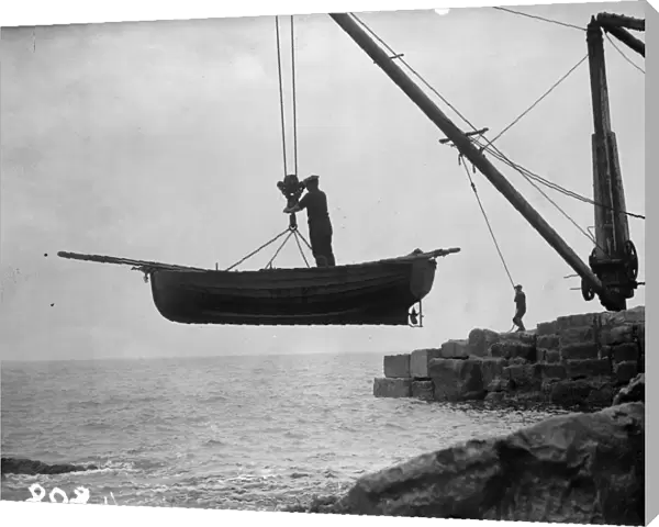 Boat Lift. Portland fishermen lifting their boat over a rocky shore by crane and winch