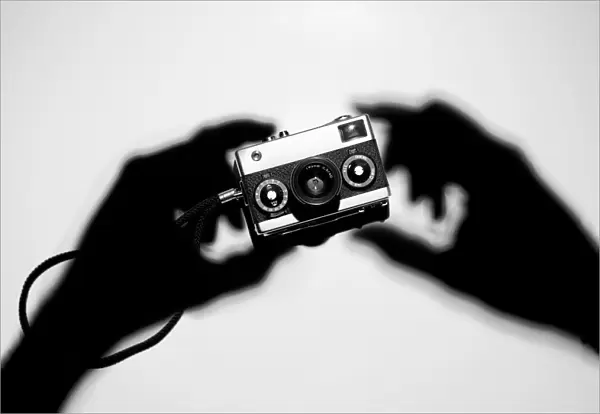 Shadow hands holding a camera