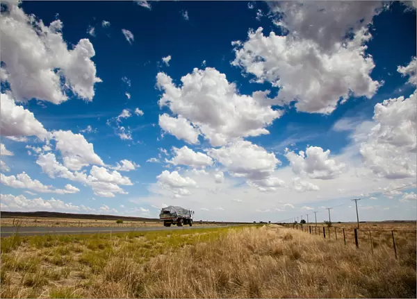 A truck travels along the N12 in the dry and arid landscape in the Northern Cape