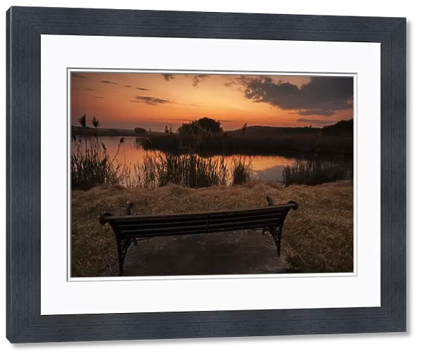 Lonesome bench landscape at sunset on the shore of a remote farm lake, Magaliesburg, Gauteng Province, South Africa