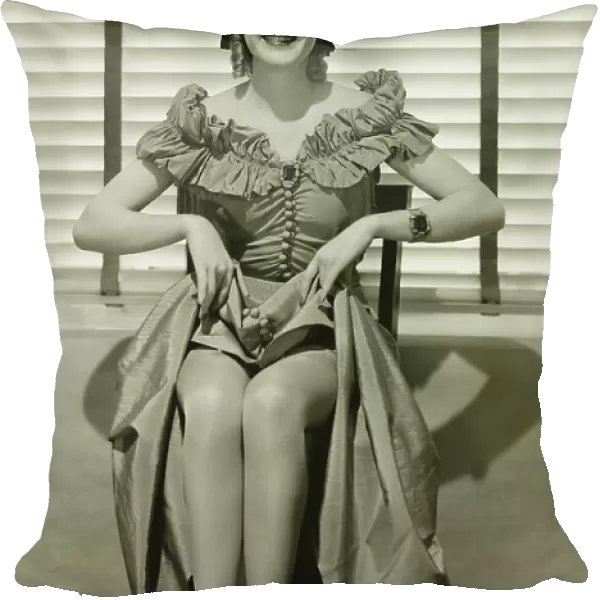 Young woman sitting on chair, showing off her legs, (B&W)