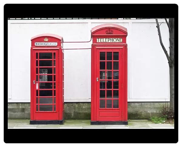 Two red telephone boxes of different vintages in London, UK credit: Marie-Louise