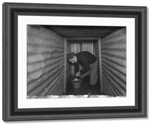 The interior of a flooded dug out in Sidcup, Kent. Mr George Harris attempts
